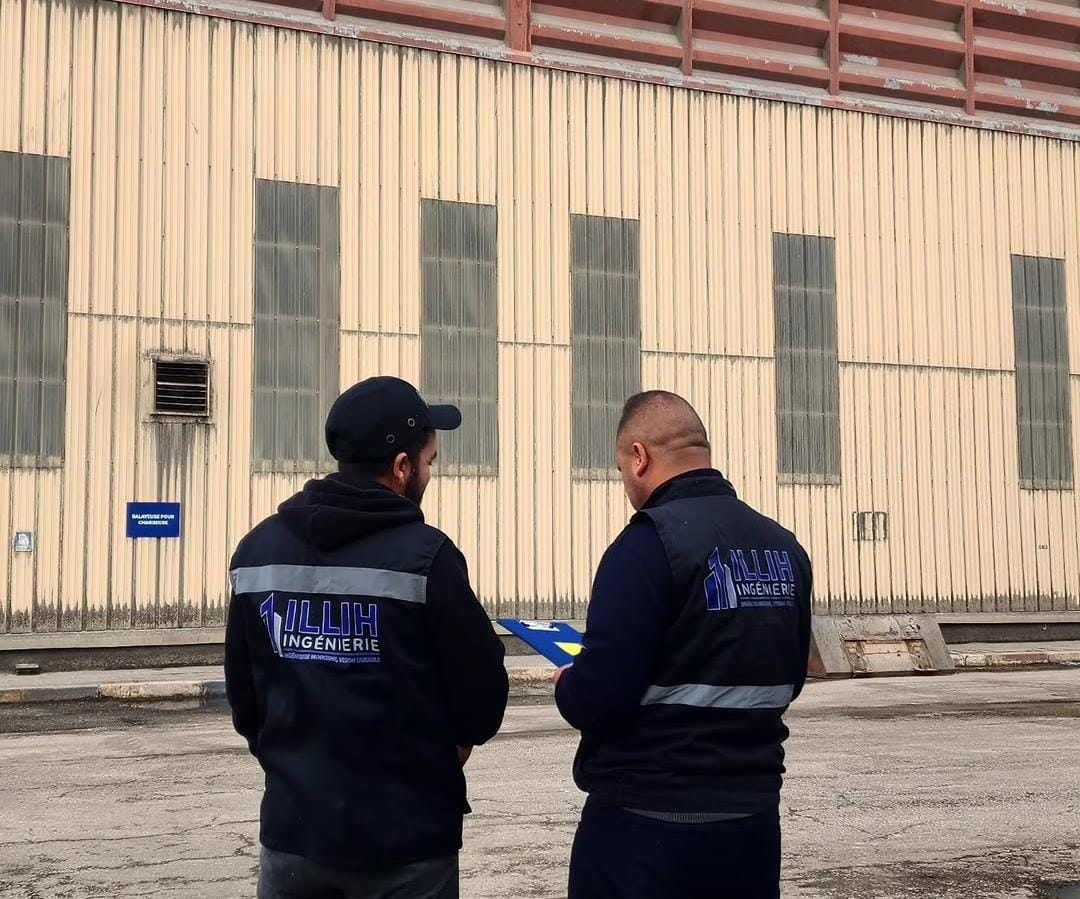 Deux membres de l'équipe ILLIH portant leurs vestes de chantier siglées